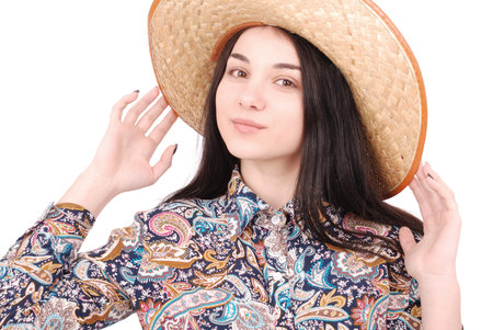 Pretty young woman wearing a big floppy straw sun hat isolated on whiteの写真素材