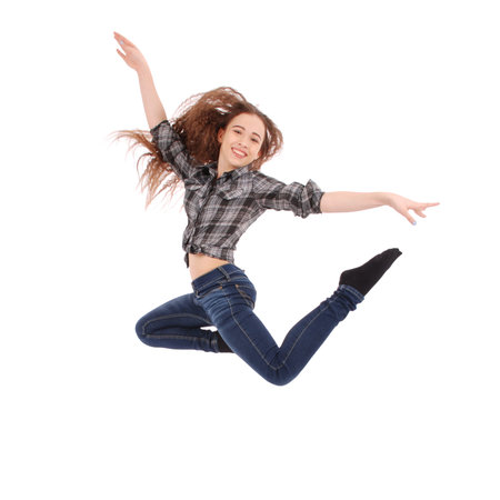 Pretty cute caucasian girl wearing a checkered shirt and blue jeans. The girl is jumping and...