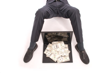 Feet of a businessman in a half-bent stanni with a laptop and money isolated on white background
