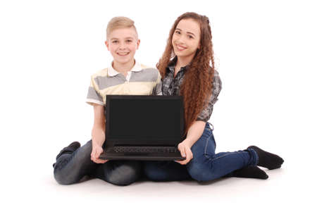 Boy and girl using a laptop isolated on white backgroundの写真素材
