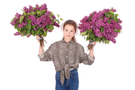 Teenage girl standing with lilac in both hands. Isolated on white backgroundの写真素材