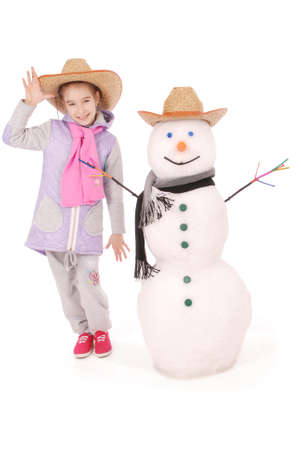 Cute girl with snowman with scarf and hat on white backgroundの写真素材
