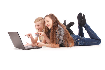 Boy and girl using a laptop lying on the floor isolated on white backgroundの写真素材
