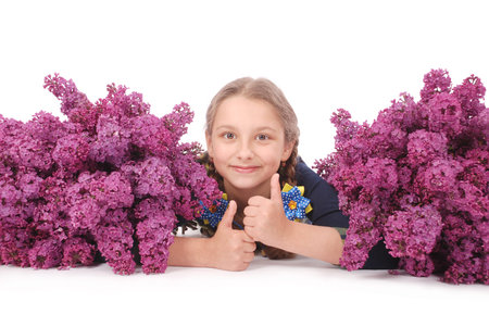 Attractive girl lying on white floor with lilac in hand. Isolated on white backgroundの写真素材