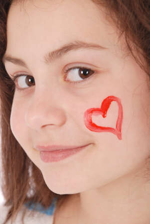 Adorable smiling little girl, with the colored dress, shows the heart isolated on a white background. Close-upの写真素材