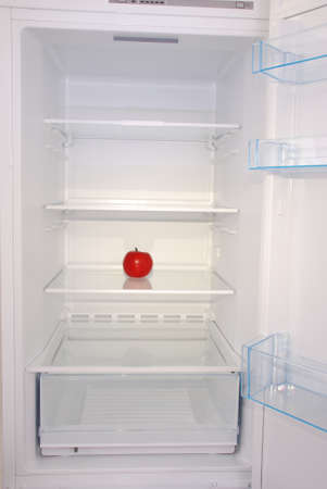 One apple in open empty refrigerator. Weight loss diet concept.の写真素材