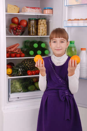Healthy eating concept. Diet. Beautiful  girl near the Fridge with healthy food. Fruits and vegetables in the refrigerator.の写真素材