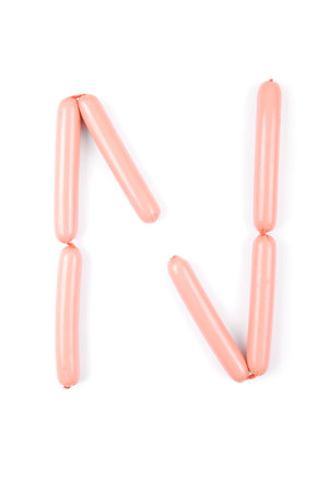 Alphabet letter N arranged from sausage isolated on the white
