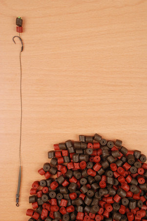 Fishing bait with hook and brown with red pre-drilled halibut pellets for carp fishing isolated on...