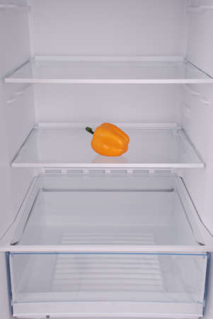 One pepper in open empty refrigerator. Weight loss diet concept.の写真素材