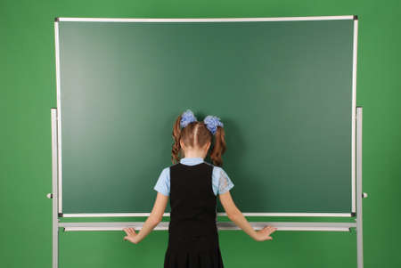 Cute girl schoolgirl near blackboard the concept of education and school lifeの写真素材
