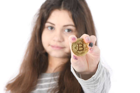 Pretty Girl holding in front of her new golden cryptocurrency bitcoin in hands on white background. Soft focusの写真素材