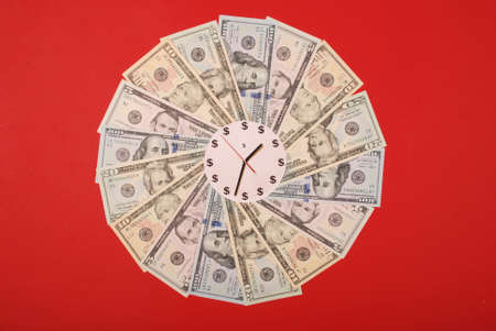 Concept of clock and dollar. Clock on mandala kaleidoscope from money. Abstract money background raster pattern repeat mandala circle. On red background.の写真素材