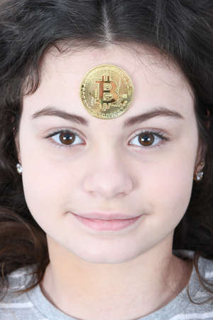 Golden cryptocurrency bitcoin on face pretty girlの写真素材