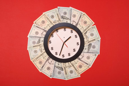 Concept of clock and dollar. Clock on mandala kaleidoscope from money. Abstract money background raster pattern repeat mandala circle. On red background.の写真素材