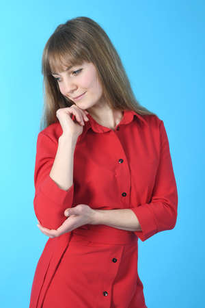 Beautiful young woman in red dress . Full length studio shot Isolated on blueの写真素材