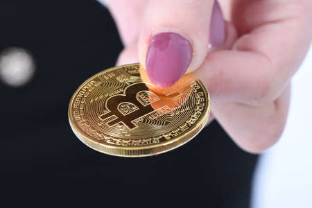 Pretty Girl holding new golden cryptocurrency bitcoin in hands on white background. Soft focusの写真素材