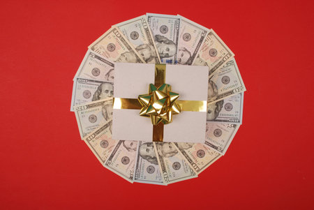 Gift on mandala kaleidoscope from money. Abstract money background raster pattern repeat mandala circle. On red background.の写真素材