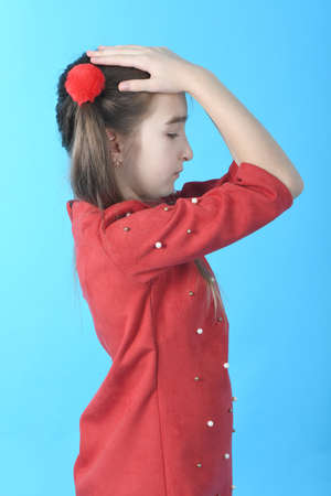 Full length studio photo girl wearing red dress standing on blue background.の写真素材