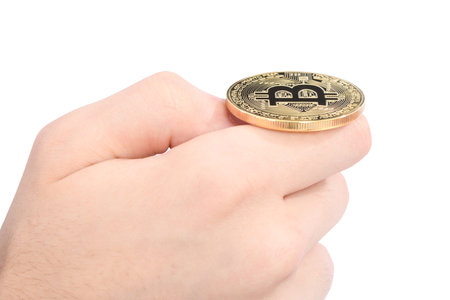 Man's hand holding golden Bitcoin on white background. High resolution photo. Full depth of field.
