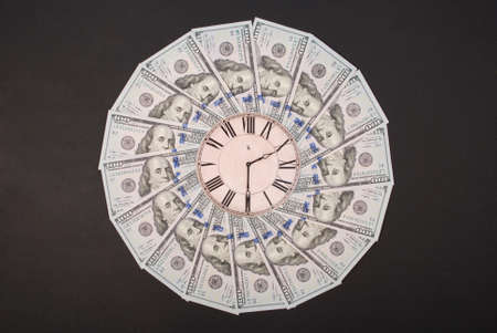Concept of clock and dollar. Clock on mandala kaleidoscope from money. Abstract money background raster pattern repeat mandala circle. On black background.の写真素材