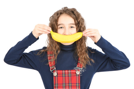 Happy girl with long curly hair making banana smile  isolated on white background. High resolution photo. Full depth of field.の写真素材