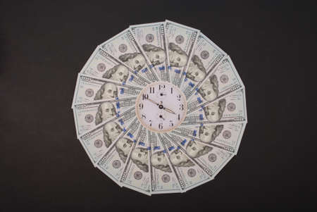Concept of clock and dollar. Clock on mandala kaleidoscope from money. Abstract money background raster pattern repeat mandala circle. On black background.の写真素材