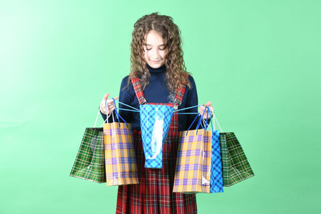 Child with a packaging checkered texture isolated on white background. Girl likes shopping on sale...
