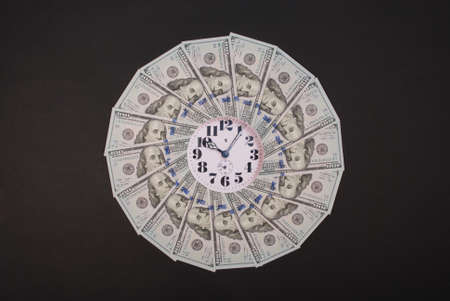 Concept of clock and dollar. Clock on mandala kaleidoscope from money. Abstract money background raster pattern repeat mandala circle. On black background.の写真素材