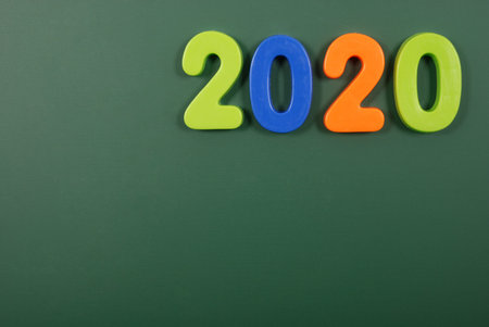 2020 year written in bright plastic magnetic letters stuck on a magnetic board