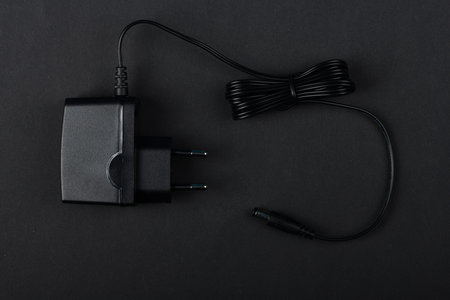 Black power ac to dc adaptor. Power adapter of router isolated on black background. High resolution...