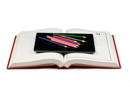 Tablet pc on opened book isolated on white background. High resolution photo. Full depth of field.