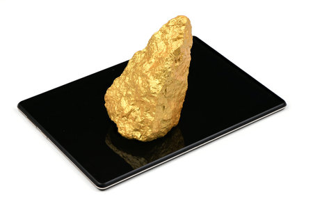 Gold nugget on tablet pc isolated on white background. High resolution photo. Full depth of field.