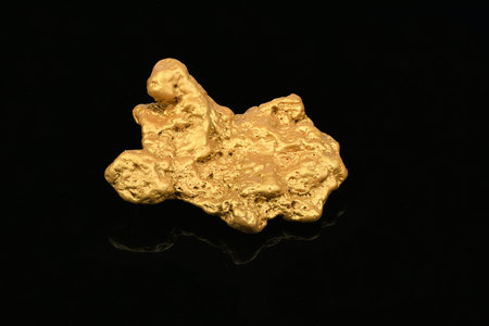 Big gold nugget on black mirror background. High resolution photo. Full depth of field.の写真素材