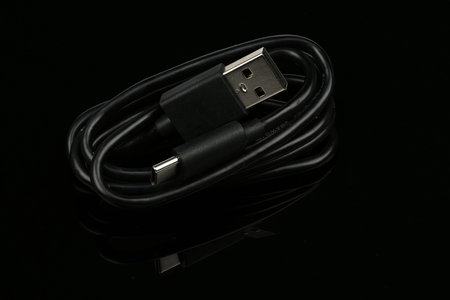  USB charging wire on black mirror background. High resolution photo. Full depth of field.