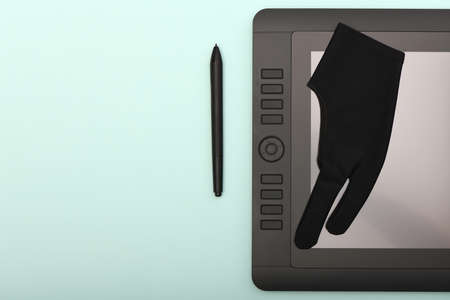 Graphic monitor stylus and glove on lime color table. Black tablet computer with blank screen. High resolution photo. Full depth of field. Working environment conceptの写真素材
