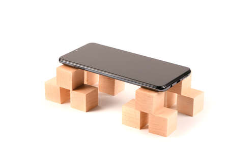 Black mobile smartphone and wooden cubes. Smartphone with blank screen. isolated on white background. High resolution photo. Full depth of field.の写真素材