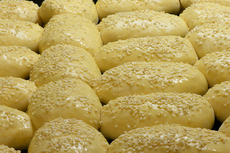 Grandma's apple pies on a baking sheet, before baking, sweet buns with sesame. High resolution...