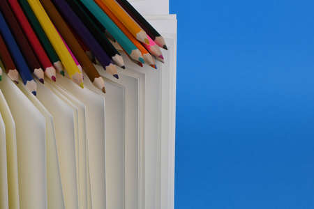 Side view of workplace with pencils on notebook on blue background. High resolution photo. Full depth of field.の写真素材