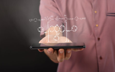 Man hand holding horizontal the black tablet computer with reaction diagram of organic chemical...