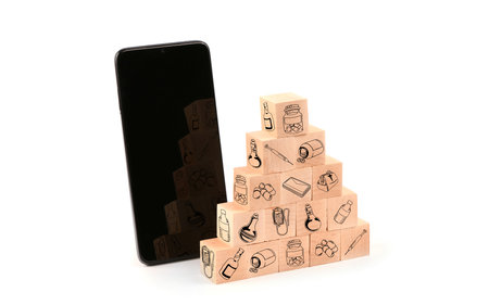 Black smartphone next to wooden blocks with healthcare medical icons. Health insurance concept. Isolated on white background. High resolution photo. Full depth of field.の写真素材