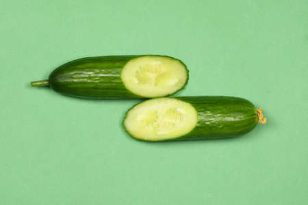 Fresh long cucumber over a green background. High resolution photo. Full depth of field.の写真素材
