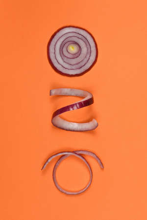 Red onion sliced into rings isolated on orange background. High resolution photo. Full depth of field.の写真素材