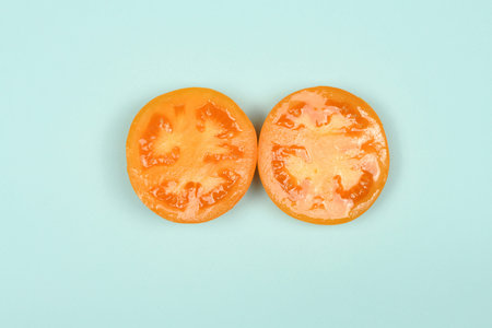 Yellow tomato isolated on blue. High resolution photo. Full depth of field.の写真素材