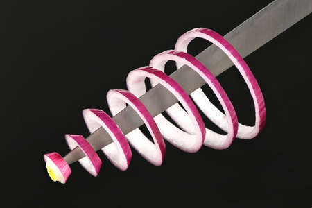 Red onion sliced into rings, symmetrically located on a knife, isolated on an acrylic black background. High resolution photo. Full depth of field.の写真素材