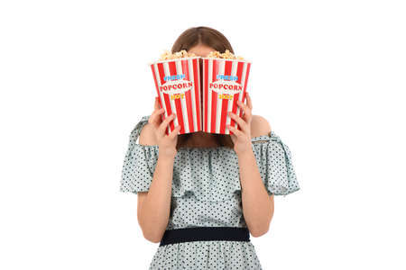 Portrait of a beautiful girl holding bucket of popcorn standing on white. High resolution photo.の写真素材