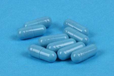 Blue medical capsules pill on blue background. High resolution photo. Full depth of field.