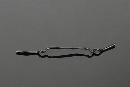 Black plastic coated wire tie used for a variety of things on black acrylic background. High...
