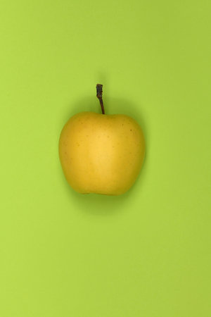 Yellow apple isolated on green. High resolution photo. Full depth of field.
