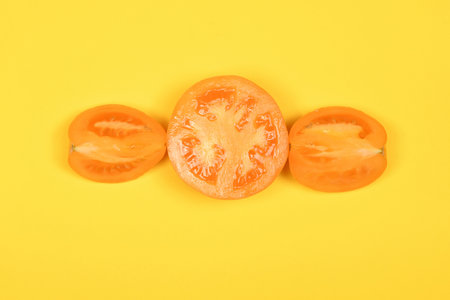 Yellow tomato isolated on yellow. High resolution photo. Full depth of field.の写真素材